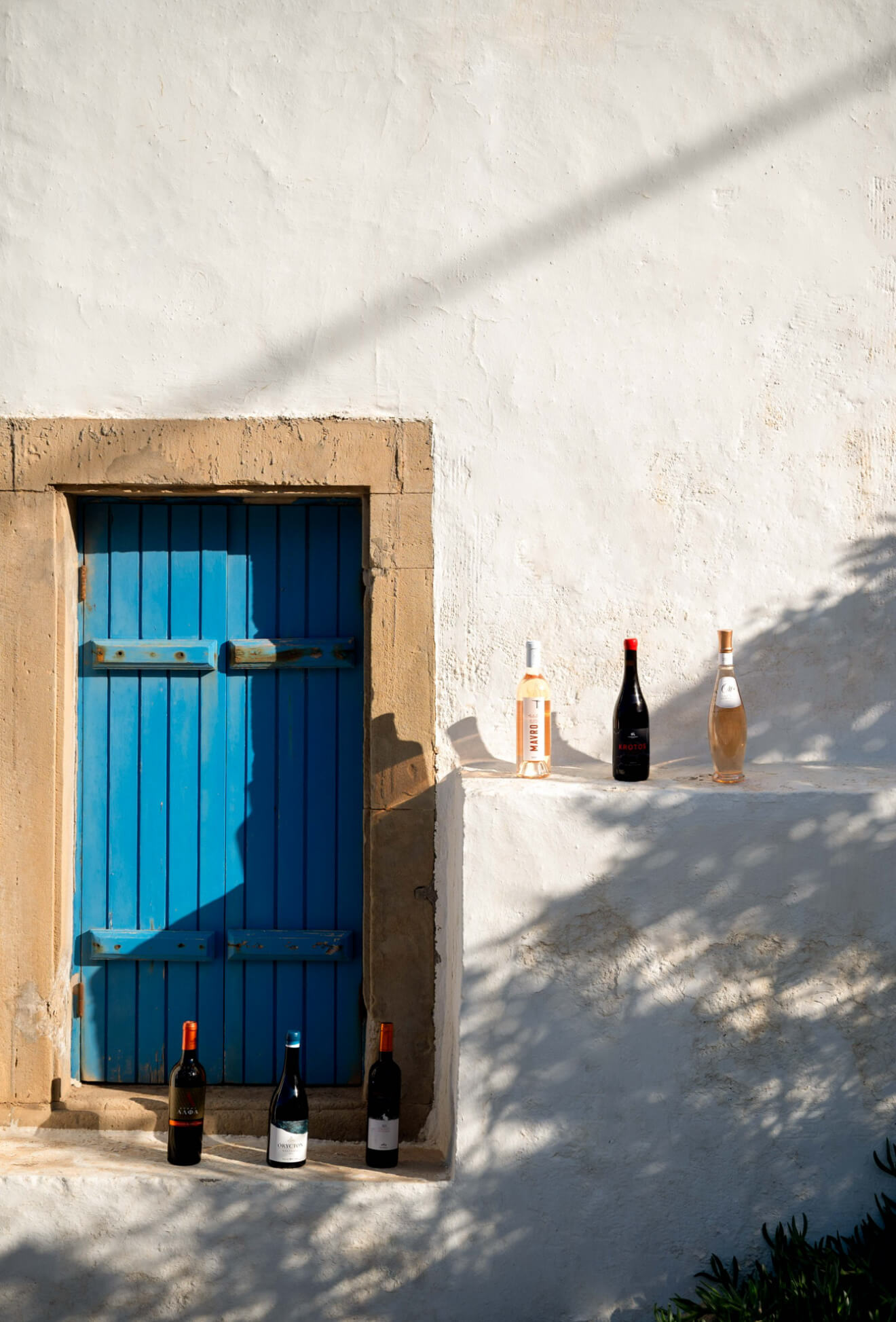 Plaka blue door with wine bottles