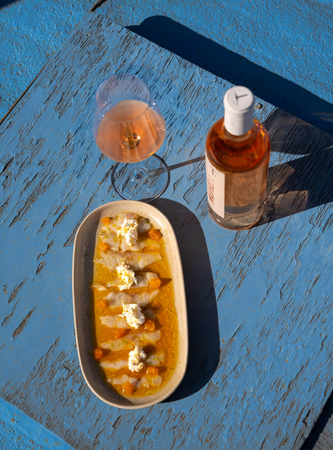 Cretan dish with rosé wine on blue table